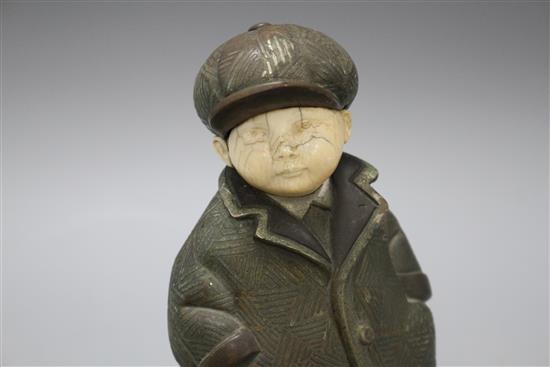 An Art Deco silver overlaid bronze and ivory figure of a boy wearing winter coat and cap, overall height 22cm, height of figure 19cm